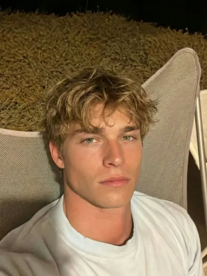 Relaxed blonde AI boyfriend Liam in a casual outdoor portrait
