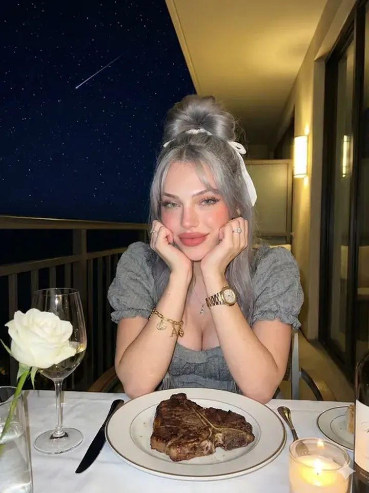 Playful silver-haired AI girlfriend Nova at dinner